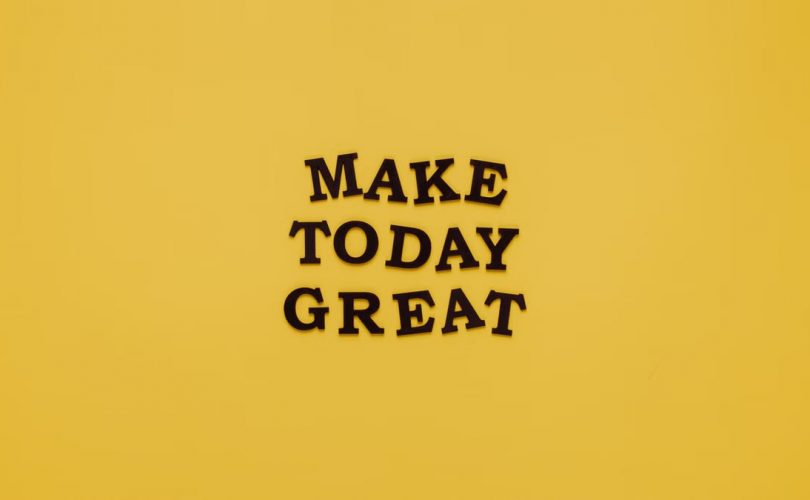 Simple and motivational quote 'Make Today Great' on a minimalist yellow background for inspiration.